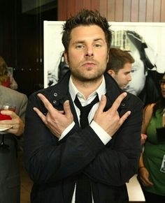 a man in a suit and tie standing with his arms crossed