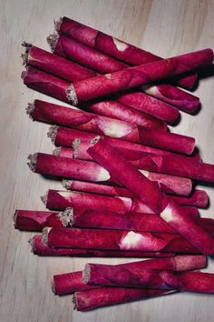 several pieces of red beet sitting on top of a wooden table