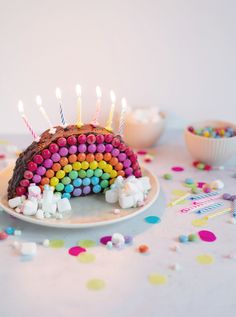 a birthday cake that has been decorated with rainbows and marshmallows on it