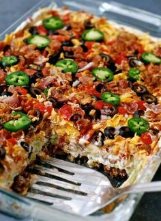 a large pizza with lots of toppings on it's crust, including jalapenos and black olives