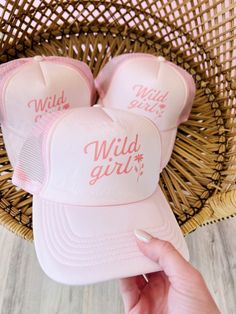 These trucker hats are our new favorites, and they will be yours too! Each style of hat has an adjustable band. Wear them with your hair down or up, and it will instantly make any outfit complete. This hat is pink with, "Wild Girl" printed in darker pink, colored text. Pink 5-panel Trucker Hat For Spring, Cute Summer Hats With Curved Bill, Trendy Spring 5-panel Trucker Hat, Pink Summer Trucker Baseball Cap, Adjustable Pink Baseball Cap For Summer, Pink Adjustable Baseball Cap For Summer, Playful Trucker Hat With Curved Brim, Pink Adjustable Trucker Hat For Summer, Pink Adjustable Trucker Mini Hats