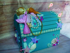 a blue box with sea shells and pearls on it