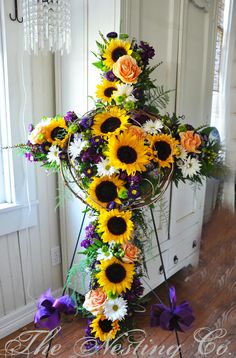 a cross decorated with sunflowers and other flowers