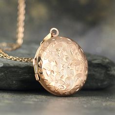 "A beautiful round locket is adorned with a floral design on the front.   The locket opens to hold photos or memories of your choosing. This round locket is made in stainless steel and is available in your choice of silver, rose or yellow.   It measures approximately 1\" (25mm) in diameter and hangs from a coordinating stainless steel chain approximately 20\" in length.    This would make a lovely keepsake for your sweetheart! - something that she could treasure and wear for many years. This locket can be engraved with your choice of personalization on the back.   Engraving will be best if you choose a short phrase, a date, names, etc.   Keep the message short as there is limited space!  Please expect subtle variances in each pendant due to handmade characteristics.   The piece you receive Vintage Rose Gold Locket Necklace Gift, Vintage Rose Gold Locket Necklace For Gift, Elegant Round Locket Necklace With Birth Flower, Elegant Round Pendant Locket Necklace With Birth Flower, Elegant Birth Flower Round Pendant Locket Necklace, Vintage Rose Gold Locket Necklace For Wedding, Rose Gold Round Locket Necklace For Gifts, Round Rose Gold Locket Necklace For Gifts, Vintage Rose Gold Jewelry With Flower Charm