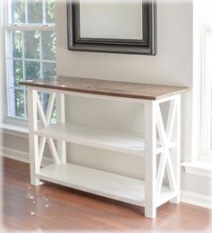 a white shelf with a mirror on top of it in front of a wooden floor