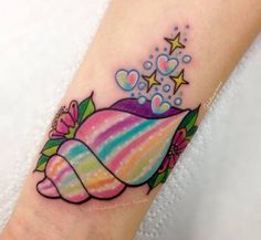 a colorful tattoo on the ankle of a woman's foot with stars and hearts