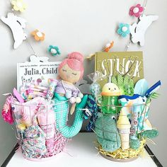 two baskets filled with baby items sitting on top of a white table next to a sign