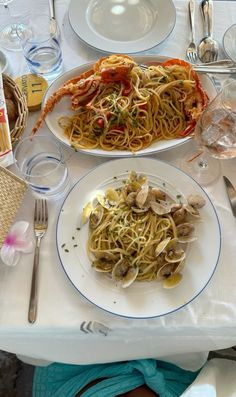 two plates of food on a table with silverware and utensils in front of them