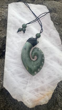 Discover the timeless allure of jade with our Hand-Carved Jade Tribal Fish Hook Necklace. Crafted with meticulous care, this necklace showcases the natural beauty and unique properties of this exquisite gemstone. Jade is renowned for its soothing and protective qualities, believed to bring harmony and balance to its wearer. Each necklace features a hand-carved jade fish hook, symbolizing strength, abundance, and good fortune. Wearing this necklace allows you to carry the calming energies of jade Nature-inspired Jade Gemstone Necklaces, Nature-inspired Jade Gemstone Necklace, Unique Green Carved Necklace, Nature-inspired Jade Pendant Necklace, Nature-inspired Jade Pendant Jewelry, Traditional Jade Gemstone Necklaces, Traditional Jade Gemstone Necklace, Artisan Jade Gemstone Necklace, Untreated Jade Jewelry Gift