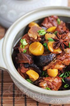 a bowl filled with meat and vegetables on top of a table