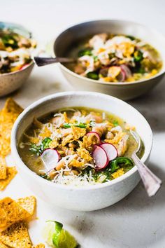 two bowls of soup with tortilla chips on the side