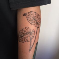 a person with a tattoo on their arm has a monster's tail and two leaves