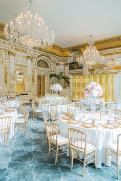 an elegant ballroom with chandeliers, tables and chairs