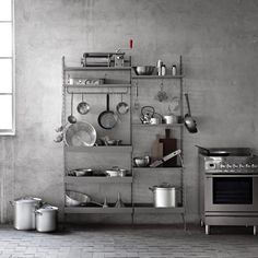 an industrial kitchen with pots and pans on shelves