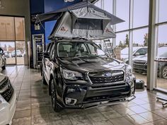 a subarunt is parked in a showroom with other vehicles