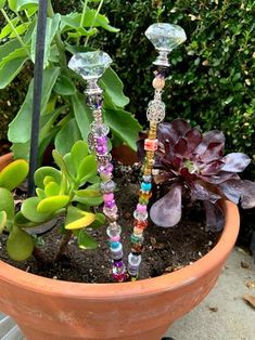 three glass candlesticks are sitting in a flower pot