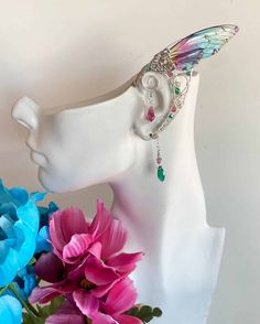 This Pair of Handcrafted Ear wraps with Acrylic Wings has been created using Sterling Silver Wires, with Teal and Pink Swarovski Crystals. They are Comfortable and easy to wear with a Hoop on the back making it easy to adjust; Perfect for any Festive event, Cosplay, or night out on the Town. All Items are made to order. If you have something Special in mind… Please Contact us… We Love Custom Orders. Adjustable Wire Wrapped Wrap Earrings For Party, Adjustable Bohemian Wrap Earrings For Party, Handmade Fantasy Wrap Earrings, Whimsical Iridescent Earrings With Ear Wire, Bohemian Iridescent Jewelry With Ear Wire, Whimsical Adjustable Ear Cuff For Festivals, Pink Flower Earrings With Resin And Ear Wire, Blue Teardrop Crystal Earrings With Ear Wire, Pink Crystal Dangle Earrings With Ear Wire