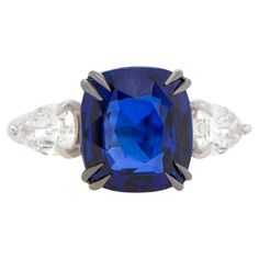 a blue sapphire and diamond ring with three diamonds on the side, set in white gold