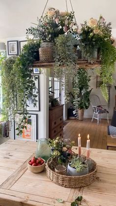 a wooden table topped with plants and candles