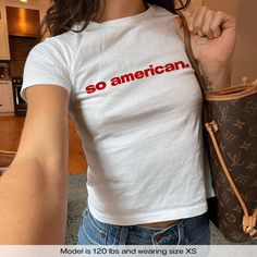 "So American 4th Of July USA" Graphic Slogan Printed On Aesthetic Retro Vintage 90s Y2k Baby Tee Shirt with our own unique font.  🎨 Available in White, Light Pink, Light Blue, Navy, Black. If you need a different color, please let us know! (Ash, Red, Sport Grey & Green)  🎁 Our baby tees are perfect gift for her or him offering timeless fashion and versatility that anyone will cherish. Baby tees, popular in the '90s, have short sleeves and a slightly cropped body, giving a flattering feminine s Fitted Logo Print Shirt For Summer, Fitted Summer Shirt With Logo Print, Summer Fitted Shirt With Logo Print, Y2k Streetwear Pre-shrunk Tops, Unisex Summer Top With Logo Print, Retro Fitted Top, Retro Fitted Pre-shrunk Top, White Y2k Pre-shrunk Tops, 90s Cotton Tops With Logo Print