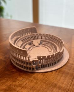 a model of an arena sits on a wooden table