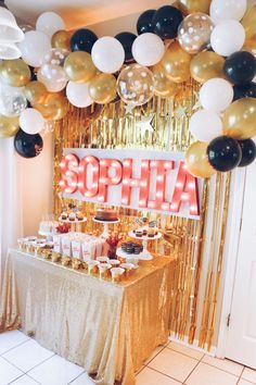 a table topped with lots of desserts and balloons