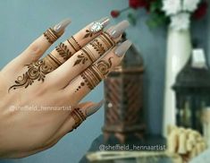 a woman's hand with henna tattoos on it