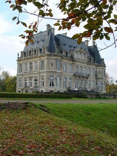 a large building with lots of windows on top of it's roof and grass in front of it