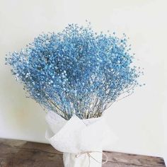 a bouquet of blue flowers in a white vase