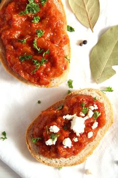 two pieces of bread with tomato sauce and cheese on them