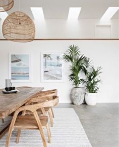 a dining room table with chairs and plants