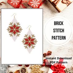 a pair of red and white cross stitch earrings on top of a table next to presents