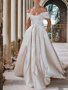 a woman in a white wedding dress standing on the steps with her hands on her hips