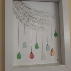 a white frame with some green and orange ornaments hanging from it