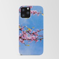 an iphone case with pink flowers on it and blue sky in the backgroud