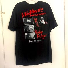 a black t - shirt hanging on a white door with the words nightmares on it