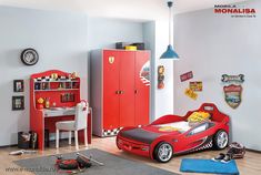 a child's bedroom decorated in red and white with cars on the bed, desk, bookshelf and toys