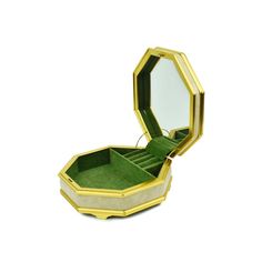 an open jewelry box sitting on top of a white table next to a green carpet