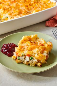 a green plate topped with food next to a casserole dish