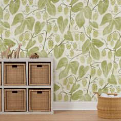 the wallpaper in this room is green and has many leaves on it, as well as wicker baskets