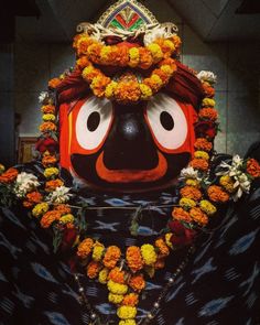 an elaborately decorated mask with flowers around it