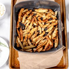 a pan filled with french fries on top of a table