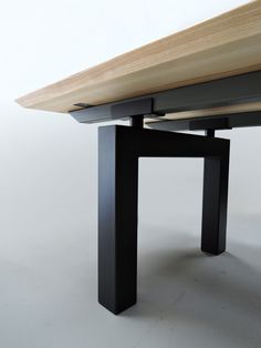 a close up of a table with a wooden top and metal legs on white background