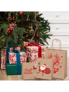 christmas presents under the tree with gifts wrapped in red and green paper bags next to it