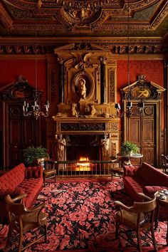 an ornately decorated living room with red couches and antique furniture in front of a fireplace