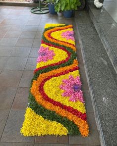 a long flower arrangement on the ground in front of a building