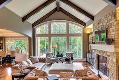 a living room filled with lots of furniture and a fire place in the middle of it