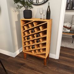 a wooden cabinet with wine bottles and glasses on it in front of a wall clock