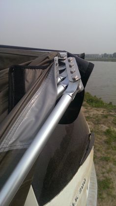 the back end of a motorcycle parked next to a body of water with a guitar case on it