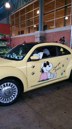 a yellow car with a cartoon dog on it's side